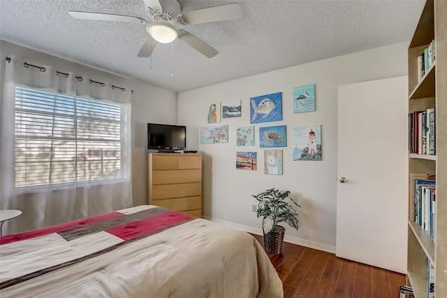 bedroom featuring a textured ceiling, ceiling fan, and dark wood-type flooring