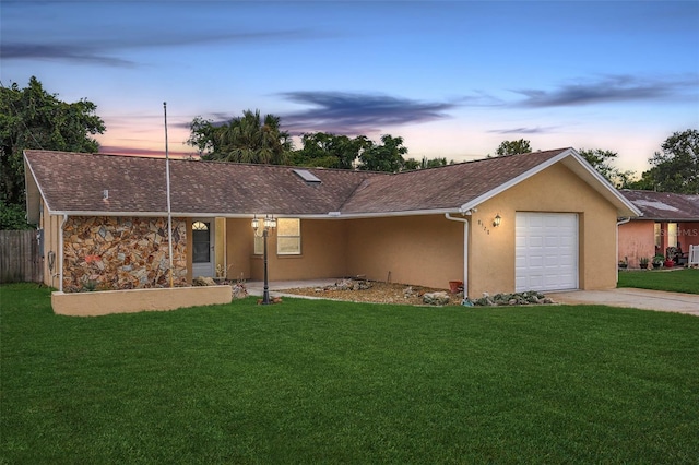 ranch-style house featuring a garage and a lawn