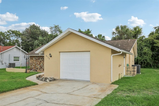 garage featuring central air condition unit and a lawn