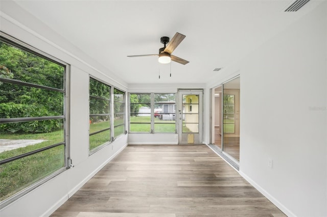 unfurnished sunroom with ceiling fan