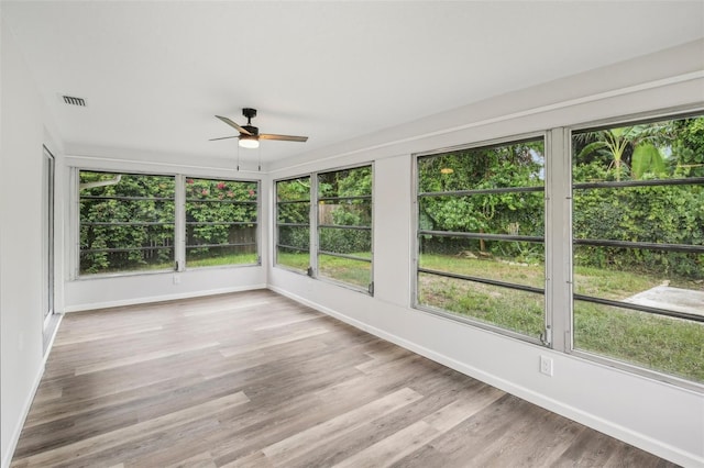 unfurnished sunroom featuring a healthy amount of sunlight and ceiling fan