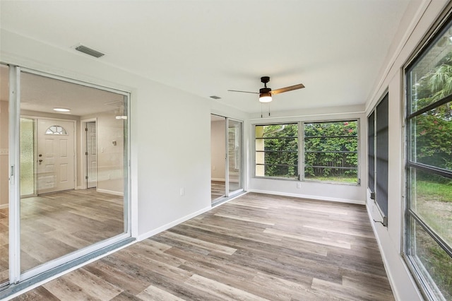 unfurnished sunroom featuring ceiling fan