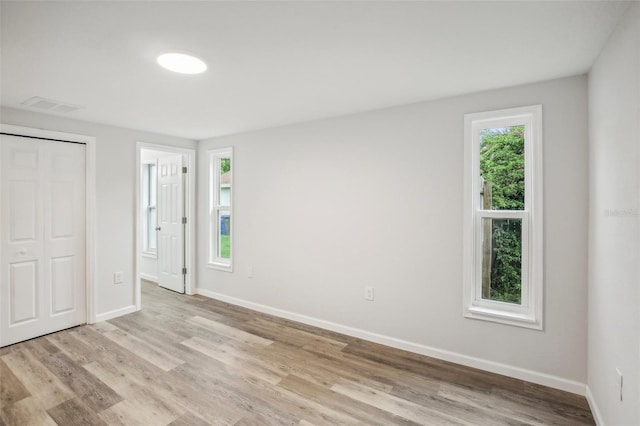 unfurnished bedroom featuring a closet and light wood-type flooring