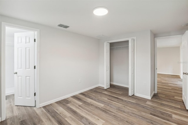 unfurnished bedroom with hardwood / wood-style flooring and a closet