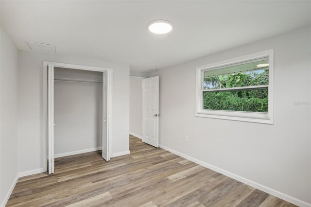 unfurnished bedroom with hardwood / wood-style flooring and a closet