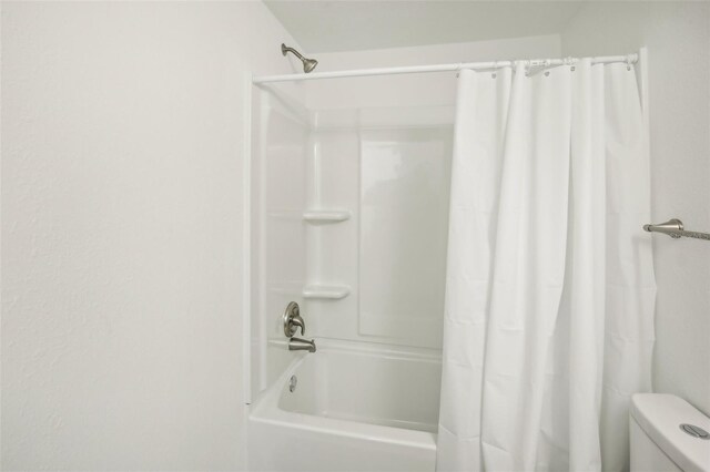 bathroom with toilet and shower / bath combo