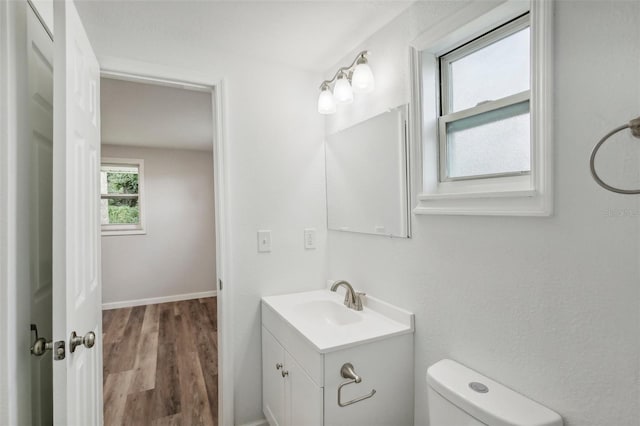 bathroom with vanity, toilet, and hardwood / wood-style flooring