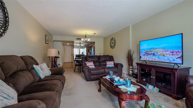 living room featuring an inviting chandelier, carpet, and a textured ceiling