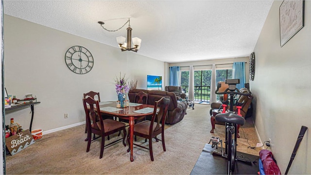 dining space with a notable chandelier, carpet floors, and a textured ceiling