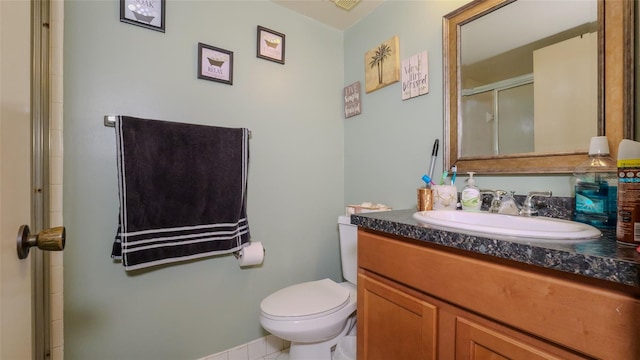 bathroom with toilet, vanity, and an enclosed shower