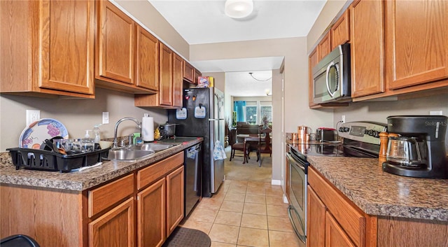 kitchen with light tile patterned floors, stainless steel appliances, and sink