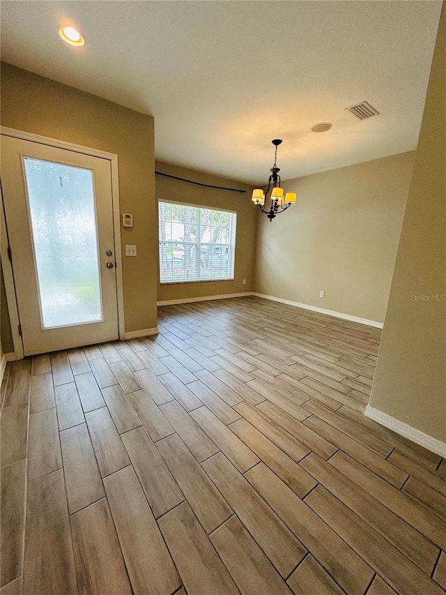 interior space with a notable chandelier and light hardwood / wood-style flooring