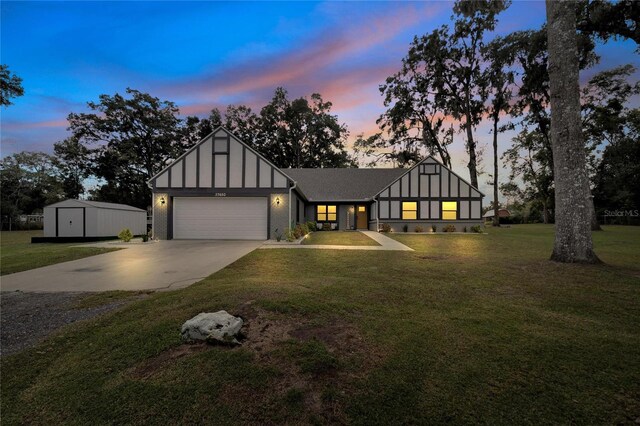 tudor home featuring a yard and a garage