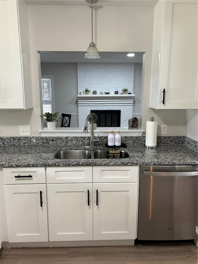 kitchen featuring wood-type flooring, stainless steel dishwasher, white cabinetry, and pendant lighting