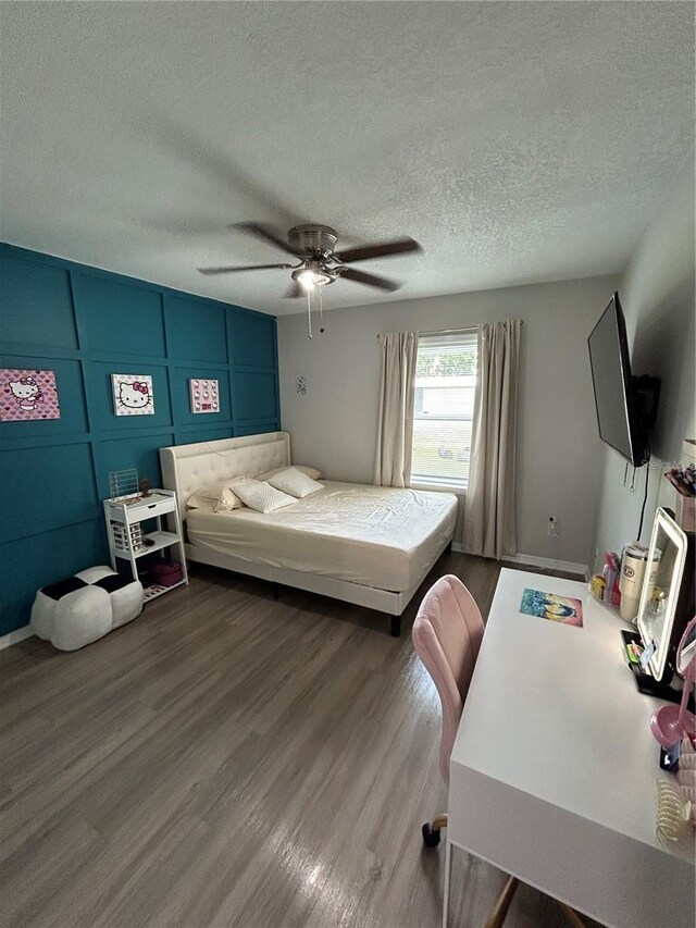 bedroom featuring a textured ceiling, wood-type flooring, and ceiling fan