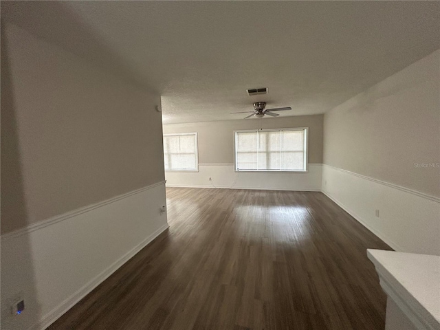 unfurnished living room featuring ceiling fan and dark hardwood / wood-style flooring