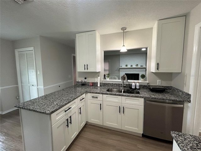 kitchen featuring sink, white cabinetry, decorative light fixtures, dark hardwood / wood-style flooring, and stainless steel dishwasher