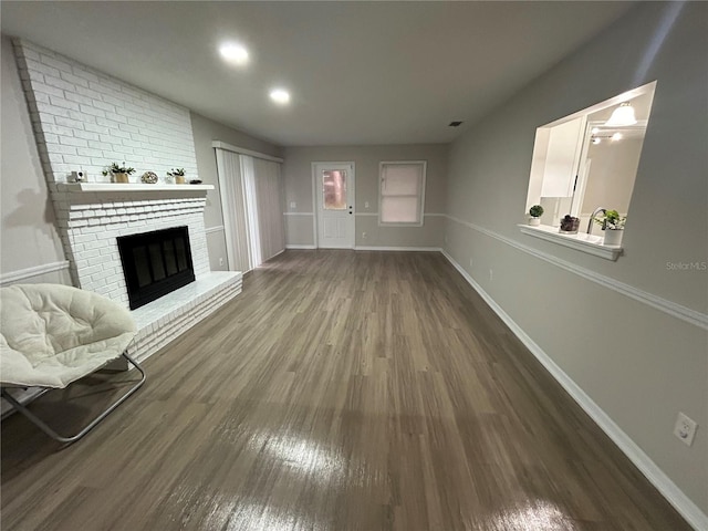 unfurnished living room with a fireplace and dark hardwood / wood-style flooring