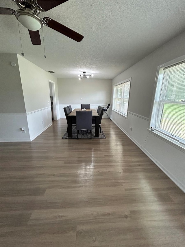 dining room with a textured ceiling, dark hardwood / wood-style floors, and ceiling fan