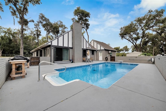 view of swimming pool with a patio and a diving board