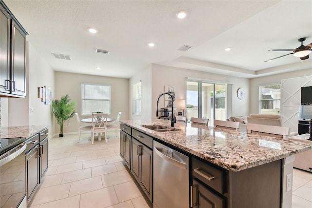 kitchen with sink, a healthy amount of sunlight, a kitchen island with sink, dishwasher, and ceiling fan