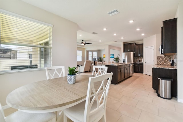 tiled dining space featuring sink and ceiling fan