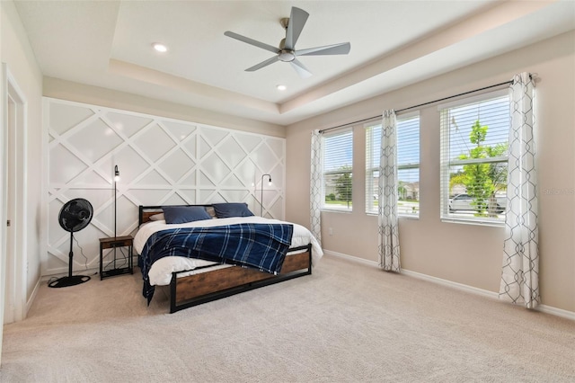 bedroom featuring carpet flooring, ceiling fan, and a tray ceiling