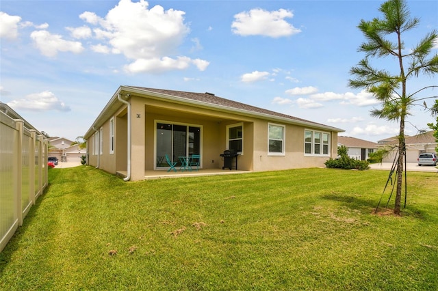 back of property featuring a yard and a patio