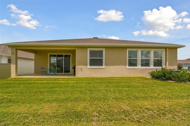 rear view of house with a yard and a patio area