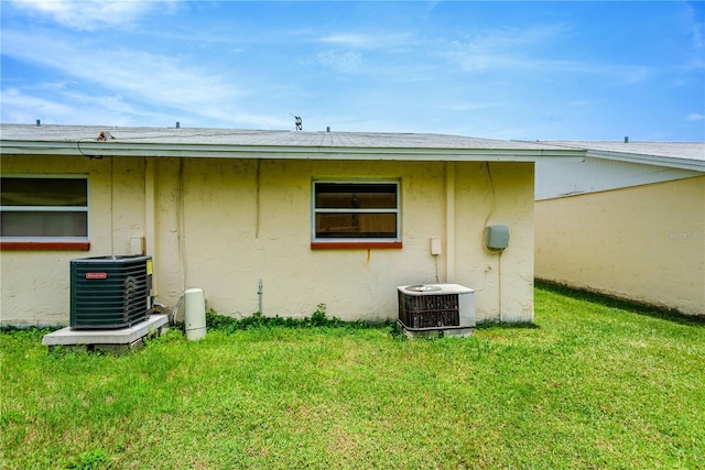 back of property featuring a yard and cooling unit