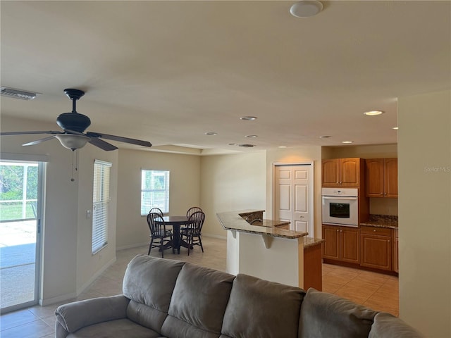 living room featuring plenty of natural light, ceiling fan, and light tile patterned floors