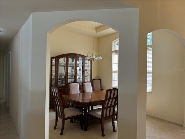 dining room featuring an inviting chandelier and a tray ceiling