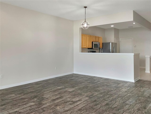 unfurnished living room with a notable chandelier and hardwood / wood-style floors