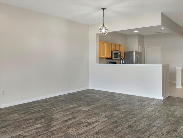 interior space with stainless steel appliances, dark hardwood / wood-style flooring, and hanging light fixtures