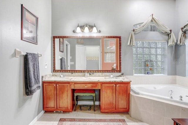 bathroom with tiled tub, vanity, and tile patterned floors