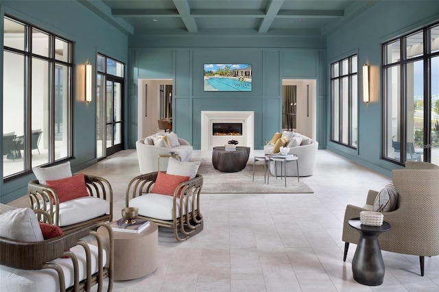 sunroom featuring a warm lit fireplace, coffered ceiling, and beam ceiling