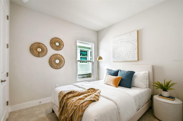 bedroom with baseboards and carpet