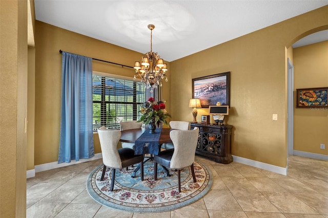 tiled dining room with an inviting chandelier