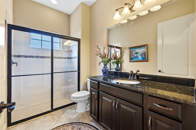 bathroom with tile patterned floors, vanity, an enclosed shower, and toilet