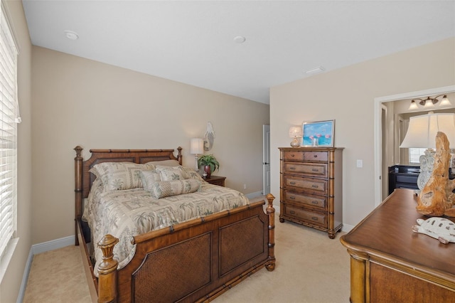 bedroom featuring light carpet and multiple windows