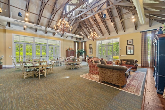 living room featuring an inviting chandelier, beamed ceiling, french doors, and high vaulted ceiling