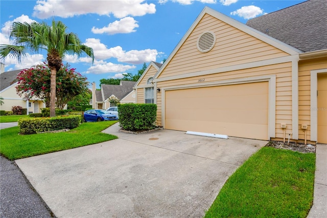 view of side of home with a garage and a lawn