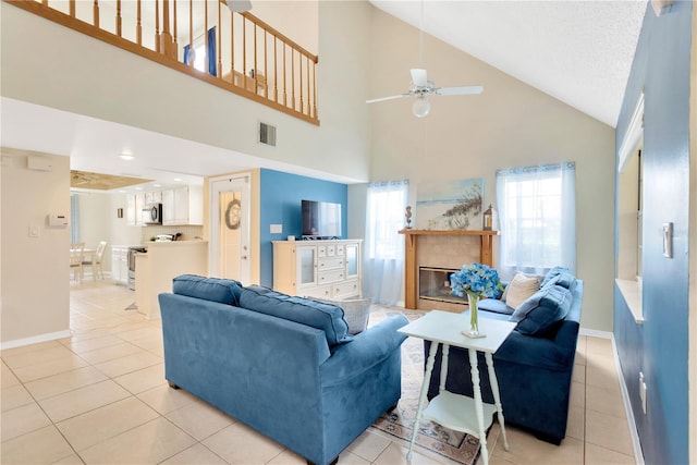 living room featuring light tile patterned floors, ceiling fan, and high vaulted ceiling