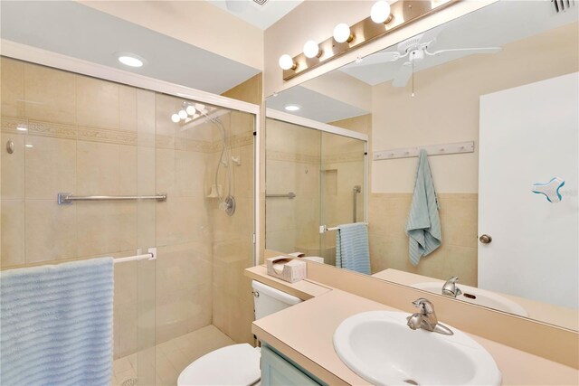 bathroom with vanity, toilet, ceiling fan, and an enclosed shower