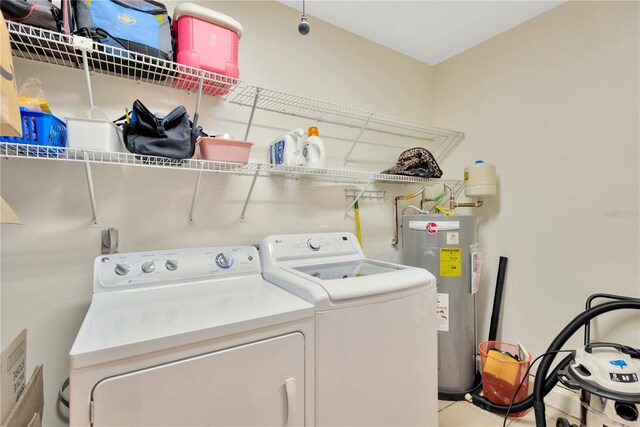 laundry room with washing machine and clothes dryer and water heater