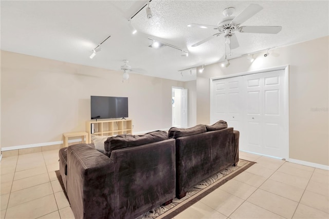 tiled living room with a textured ceiling, rail lighting, and ceiling fan