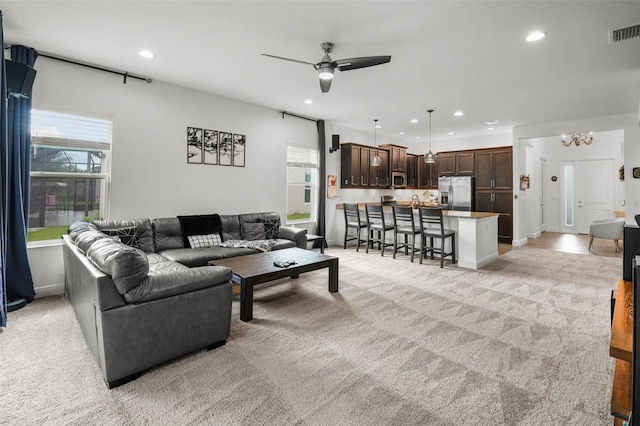 carpeted living room with ceiling fan