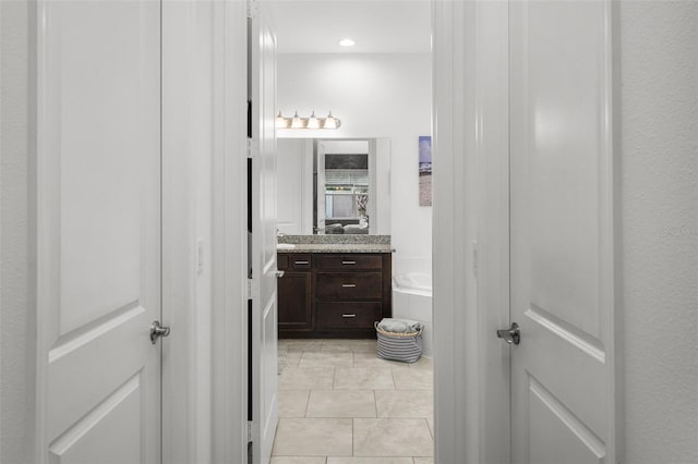 bathroom with vanity, a bathtub, and tile patterned floors