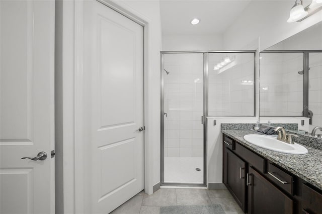 bathroom featuring tile patterned floors, a shower with shower door, and vanity