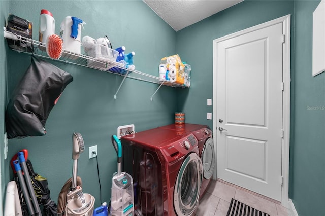 laundry room with separate washer and dryer, light tile patterned floors, and a textured ceiling